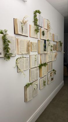 several books are arranged on the wall with plants growing out of them and attached to it