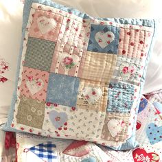 a close up of a patchwork pillow on a bed