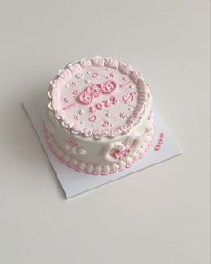 a pink and white cake on top of a card with the number 50 on it