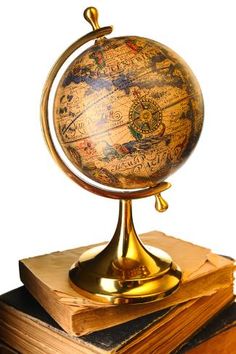 an antique globe on top of several books