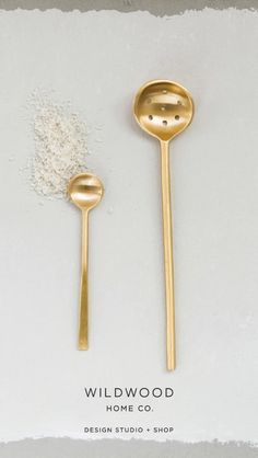 two gold spoons sitting next to each other