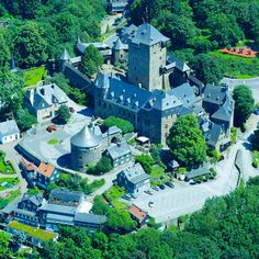 an aerial view of a large castle in the middle of a town with lots of trees