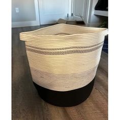 a large white basket sitting on top of a wooden floor