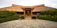 the entrance to a house with a thatched roof and steps leading up to it