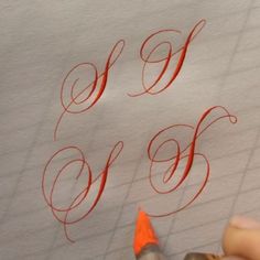 someone is writing the letters w and f on paper with orange crayon pencils