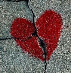 two red hearts drawn on cracked concrete