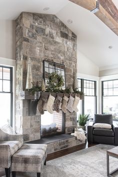 a living room filled with furniture and a fire place in front of a stone fireplace