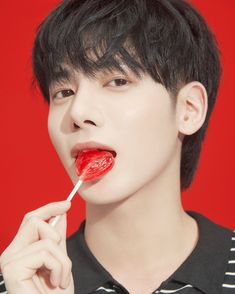 a young man holding a lollipop in his mouth