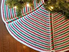 two knitted christmas umbrellas sitting on top of a wooden floor next to a tree