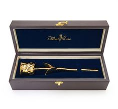 an open box with a gold rose in it