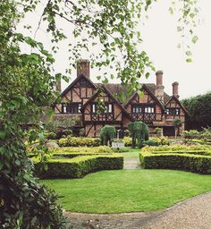 a large house with hedges in front of it