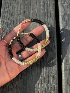 Embrace your bohemian spirit with our handcrafted Black & Gold Wire Wrapped Hoop Earrings. These one-of-a-kind earrings feature a mesmerizing swirl of black and gold seed beads meticulously wrapped around lightweight gold-tone hoops. Each bead is carefully secured by hand, creating a unique and textured design that catches the light and adds a touch of boho chic to any outfit.  The combination of black and gold exudes an air of sophistication, making these earrings perfect for both everyday wear and special occasions. Why You'll Love These Hoop Earrings: Handcrafted Artistry: Each pair is meticulously crafted with love and attention to detail. Unique Design: The wire-wrapped seed bead pattern ensures no two pairs are exactly alike. Bohemian Flair: Embrace a free-spirited aesthetic with the Bohemian Small Hoop Earrings For Parties, Handmade Hoop Beaded Earrings For Party, Bohemian Round Hoop Earrings For Party, Adjustable Hoop Beaded Earrings For Party, Bohemian Hoop Beaded Earrings For Party, Bohemian Beaded Hoop Earrings For Party, Bohemian Party Hoop Beaded Earrings, Circular Beaded Earrings For Festivals, Bohemian Small Hoop Beaded Earrings For Party