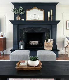 a living room with a black fireplace and white couches