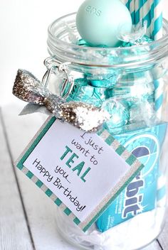 a glass jar filled with candy and a tag that says teal, happy birthday