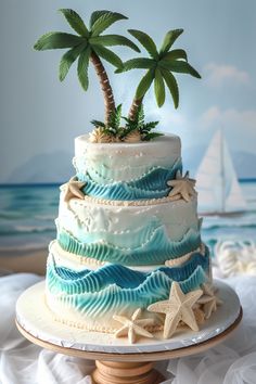 a three tiered cake decorated with palm trees and seashells on a table