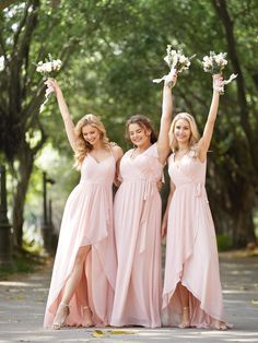 three bridesmaids in pink dresses are holding bouquets and posing for the camera