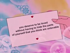 someone holding up a piece of paper that says you deserves to be loved without having to hide the parts of yourself that you think are unlovvable