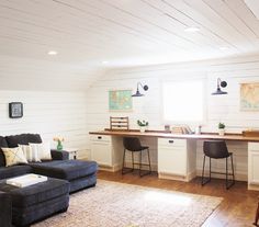 a living room filled with furniture next to a kitchen