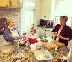 two women and a girl preparing food in a kitchen