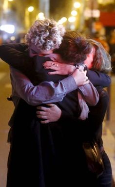 two women hugging each other on the street