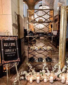 candles and flowers sit on the floor in front of a welcome sign