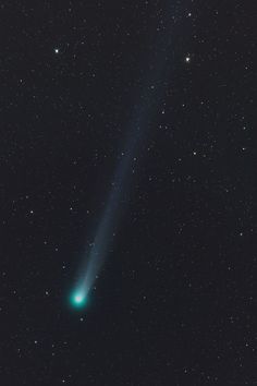 an image of a comet in the sky with stars around it and one beam visible