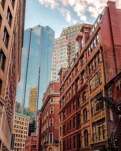 a city street filled with tall buildings next to each other and a sky scraper in the background