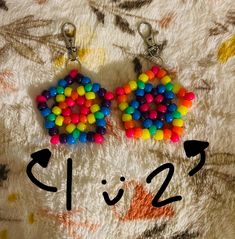 two pairs of multicolored plastic beads are on a white surface with the words clizz written below them