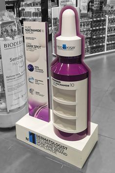 a purple and white medicine bottle sitting on top of a display case in a store