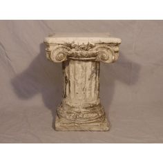 an old white marble pedestal on a gray background