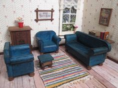 a doll house living room with blue couches, chairs and a rug on the floor