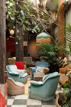 a room filled with lots of furniture next to a green plant and potted plants