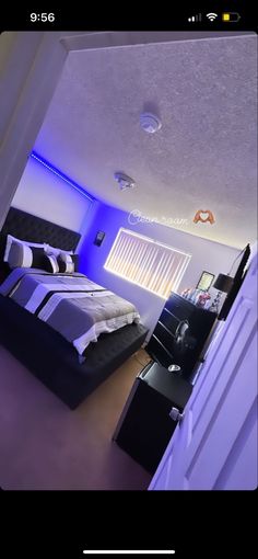 a bed room with a neatly made bed and purple lighting