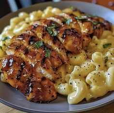 a plate with chicken, macaroni and cheese on it