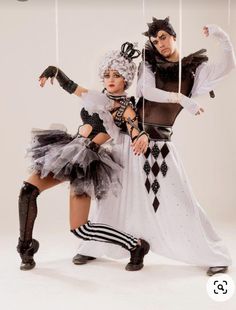 two people dressed in costumes and holding strings