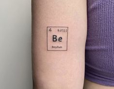 a woman's arm with the word be written on it and an element in the middle