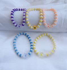 three bracelets sitting next to each other on top of a white sheet covered bed