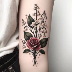 a woman's arm with flowers and leaves on it