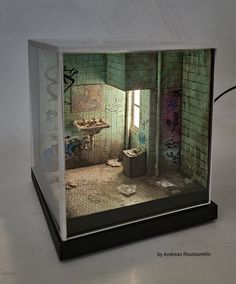 a model of a bathroom with graffiti all over the walls and floor, in a display case