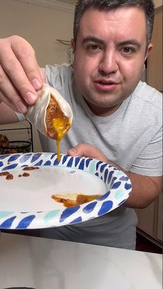 a man is eating food from a paper plate