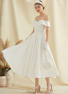 a woman in a white wedding dress standing next to a flower pot