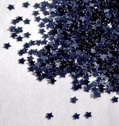 a pile of blue stars sitting on top of a white surface