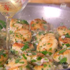 scallops being cooked in a pan with parsley