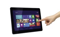 a hand pointing at the screen of a tablet computer with windows 8 operating on it