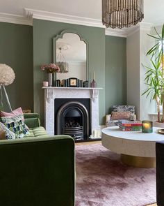 a living room filled with furniture and a fire place in front of a mirror on the wall