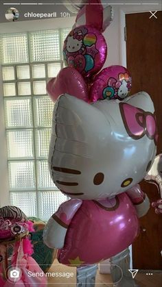 a hello kitty balloon in the shape of a cat with lots of balloons attached to it