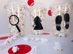 three plastic cups filled with popcorn and black silhouettes