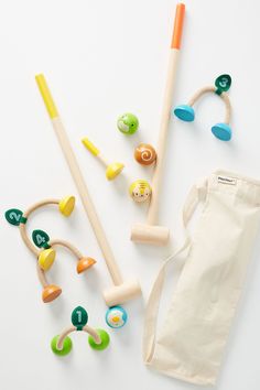 an assortment of wooden toys on a white surface with a tote bag next to it