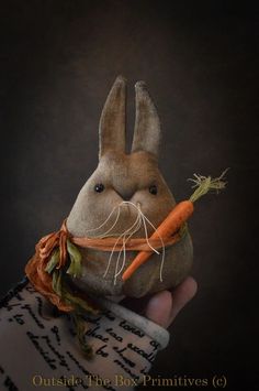 a stuffed rabbit holding a carrot in it's hand