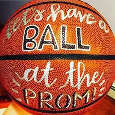 a basketball with words written on it sitting on a wooden floor next to a wall